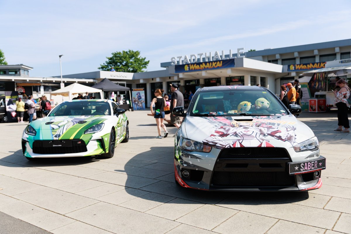 Itasha cars with anime artwork in front of the Stadthalle