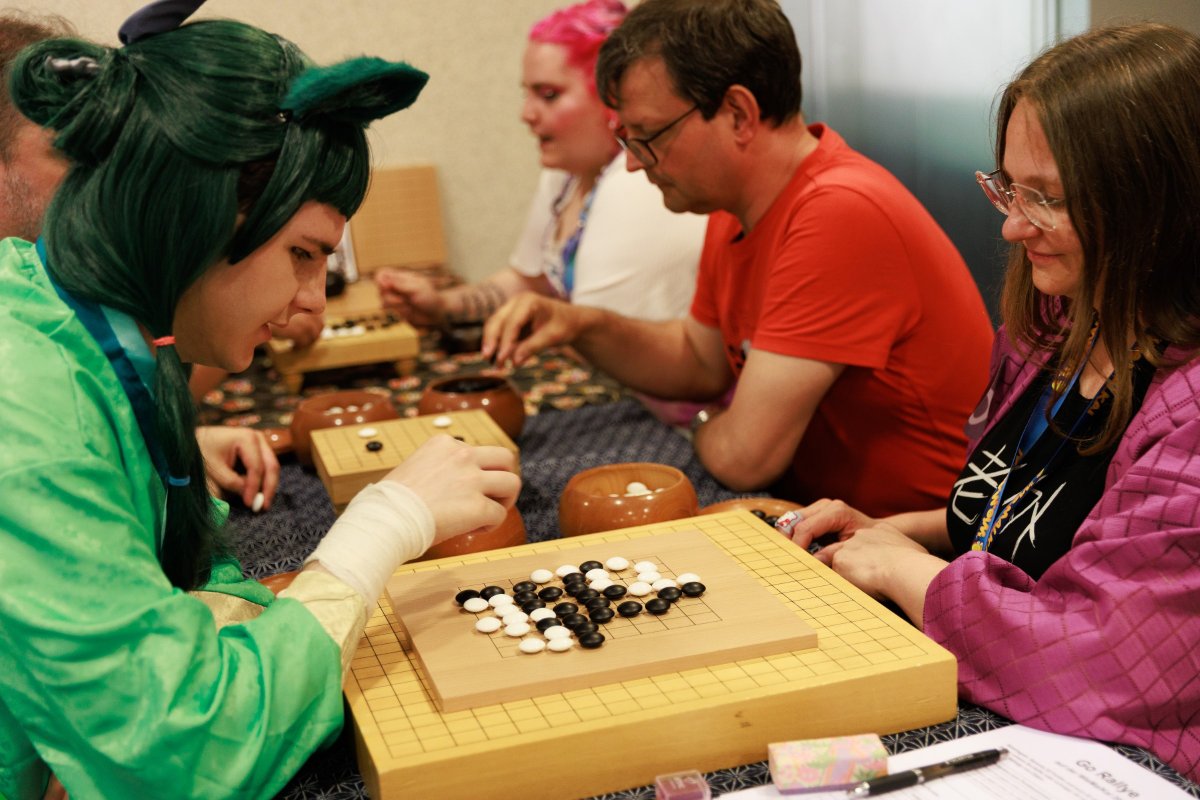 Game of Go at the games table with visitors in cosplay